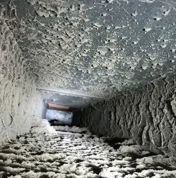 Residential air duct interior caked with heavy dust and debris before cleaning