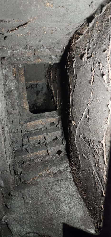 Before: a cracked, heavily sooted 1970s smoke chamber of rough unlined masonry in an Alexandria chimney