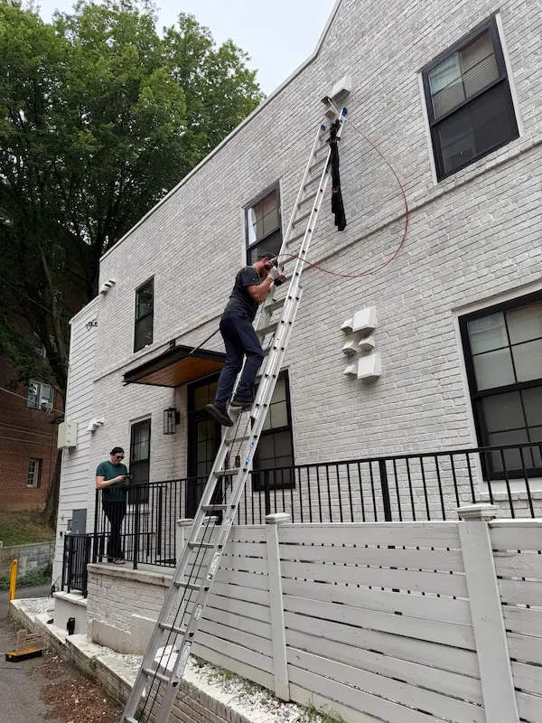 CleanFlow Pros technician servicing the exterior dryer vent of a McLean home